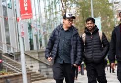 Three students walking in front of the New Adelphi Building