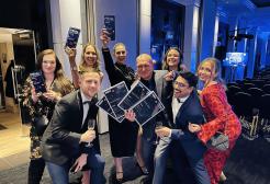 Eight MRER staff posing with awards at Pride awards