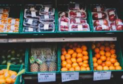 Eight crates of different fruits on a market stall