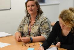 Two people sitting at a desk in a workshop