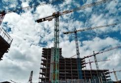 Skyline of five cranes and partly built tower blocks with scaffolding