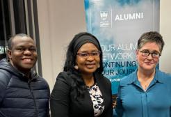 Three students taking a picture with the Dean of Salford Business School