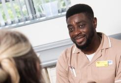 A student nurse chatting to a patient 