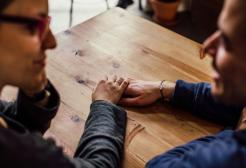 Supportive hand on a wooden table
