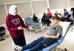 Group of physiotherapy students watching a supervisor demonstration