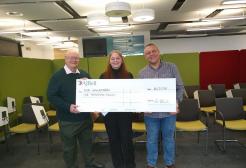 Image show Mia and her lecturers with a check for £1,000