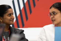 Two students sat talking in front of laptops