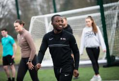 Male student looks off to the side whilst walking on the 3G Sports Pitch.