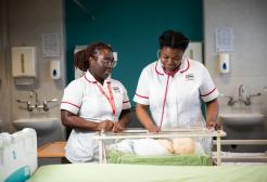 Two female student midwives conducting new-born checks.
