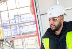 A male student on a construction site giving instructions
