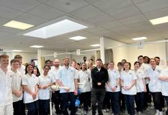 Alex Brooker standing with a large group of university students