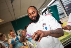 Nursing student uses a syringe to measure out medicine from a bottle