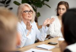 A woman gestures with her hands in a meeting