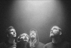 A group of people stare up at a light in a pixelated image