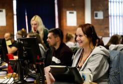 University of Salford Clearing team sat at computers with headsets answering calls and enquiries.