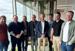 Seven representatives from GC Tech and the University of Salford smiling looking at the camera