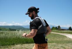 A man wearing a hat runs alone in an Italian field 