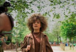 Girl walking in Salford with a camera filming her