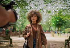 Girl walking in Salford with a camera filming her