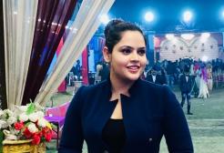 A female student looking to the left of the camera wearing a military-style black jacket