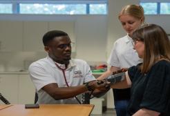 Male Clinical Exercise Physiology student conducting manual blood pressure checks on patient