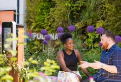 Two people sat in the garden area on campus