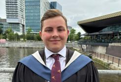 Joe Williams in graduation robes outside The Lowry