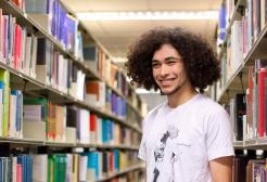 Student holding a book in the Clifford Whitworth library