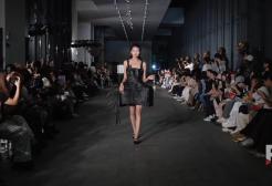 A woman walks down a dark runway at the Ningbo Museum in China