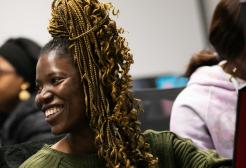 A smiling student looking to the side in a computer suite