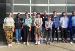 A group of people pose for a picture in a group on a sunny day