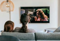 Family watching a wall mounted television set
