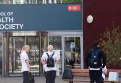 Students chatting in front of the Mary Seacole Building, University of Salford