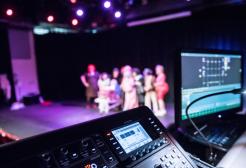 Cameras and recording equipment filming students on stage