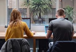 Two students work online in a library