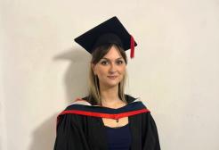 Midwifery graduate Jess in her graduation cap and gown
