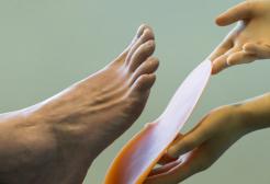 Image of podiatrist's hand near foot