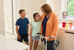 A woman with a Walk Safe walking frame talking to her grandchildren