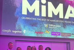 Ethan McKnight holding his awards with members of University staff