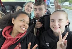 Two students taking a selfie on a bus holding up the peace sig