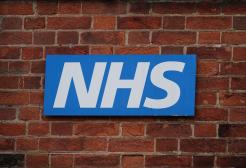 NHS logo on a brick wall