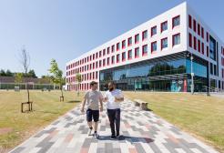 Two students walking outside the Science, Engineering & Environment (SEE) Building, University of Salford