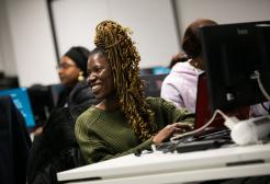 MSc FinTech student smiling in a computer suite lecture