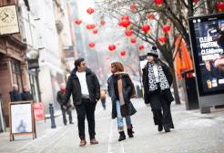 Three international students walking down King Street in Manchester