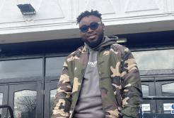 Stephen leaning on a handrail outside Maxwell Hall. 