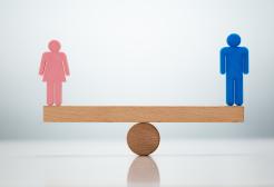 Gender equality concept with male and female cutouts balancing on a seesaw model