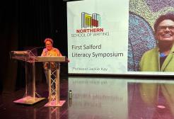Jackie Kay speaks at a lectern at Salford Literacy Symposium