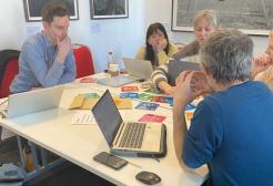 A group of people working together on a table, smiling.