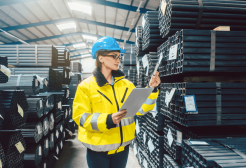 Woman reviewing stock in a steel warehouse