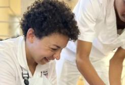 a prosthetic and orthotics student, in a uniform, helping a patient 